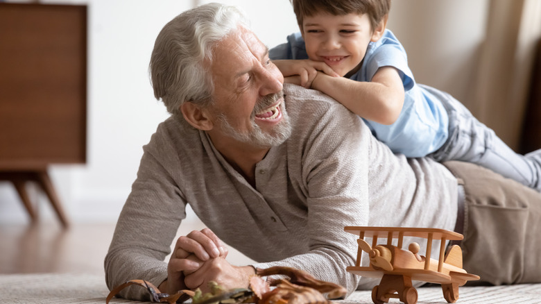 Young boy crawling on back of older man