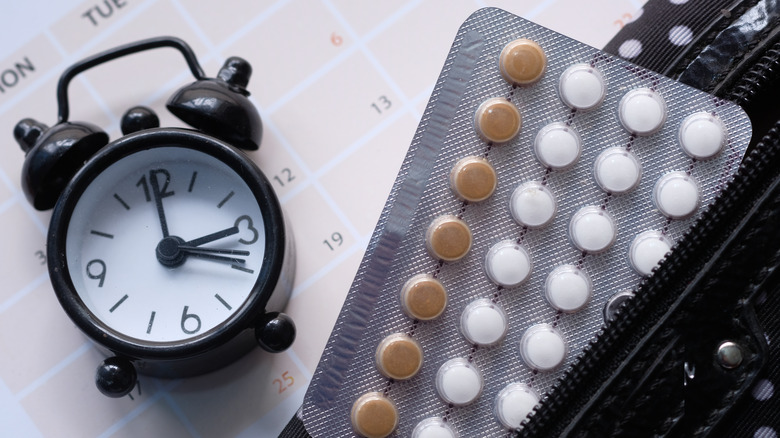 Birth control pills with clock and calendar