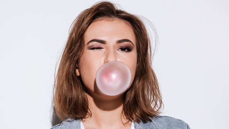 woman blowing bubble gum and winking