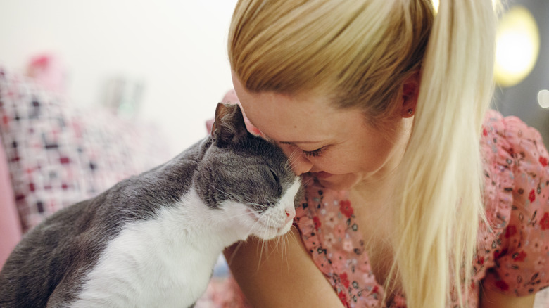 woman cuddling with cat