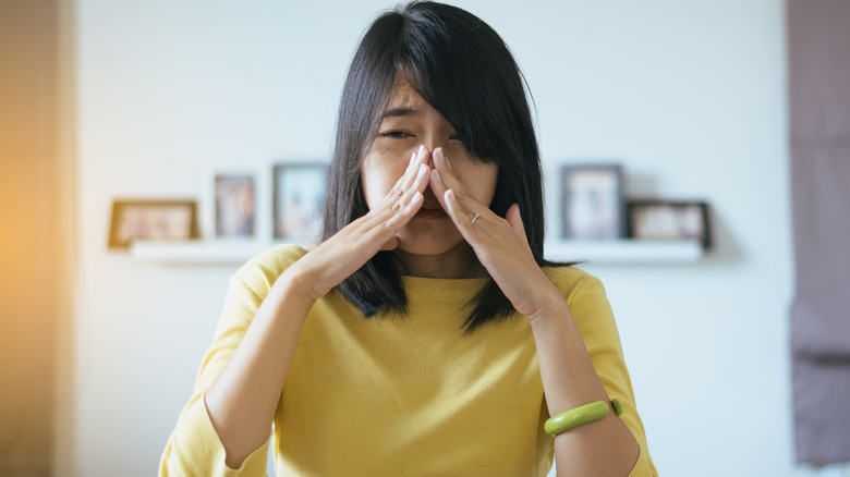 Woman pinching nose closed