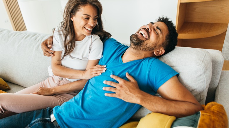 Couple laughing on couch