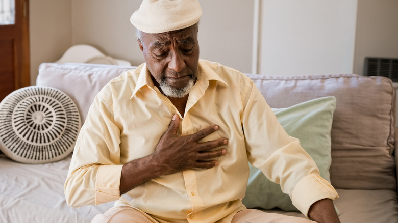 Man holding hand to chest