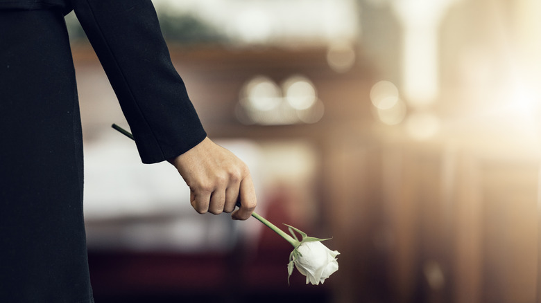 Woman holding white rose