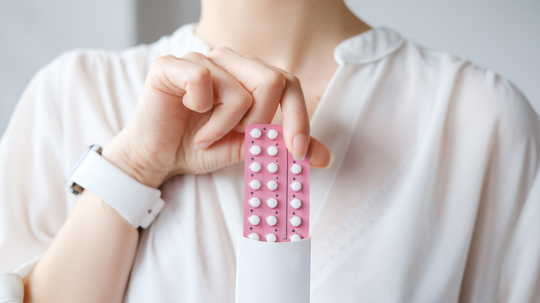 woman holding pack of birth control pills
