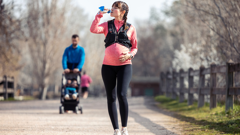 Pregnant woman drinking from bottle