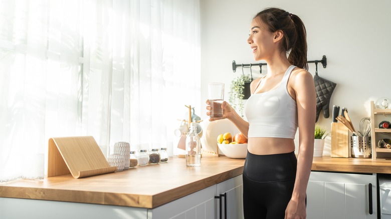 Woman in kitchen with glass of water