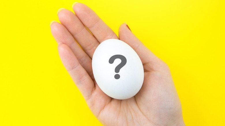 open palm holding egg with question mark