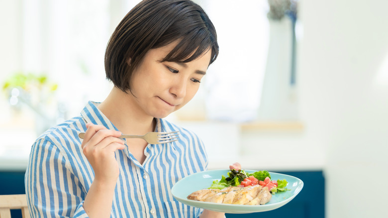 Woman considering eating chicken