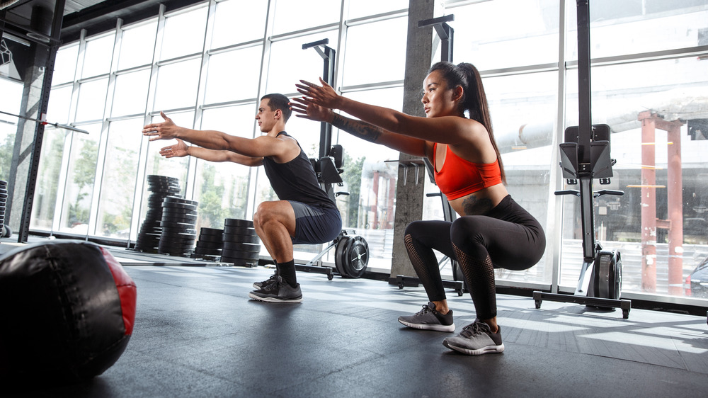 athletes squatting at gym