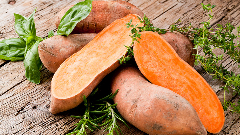 sweet potatoes halved on a wood table 