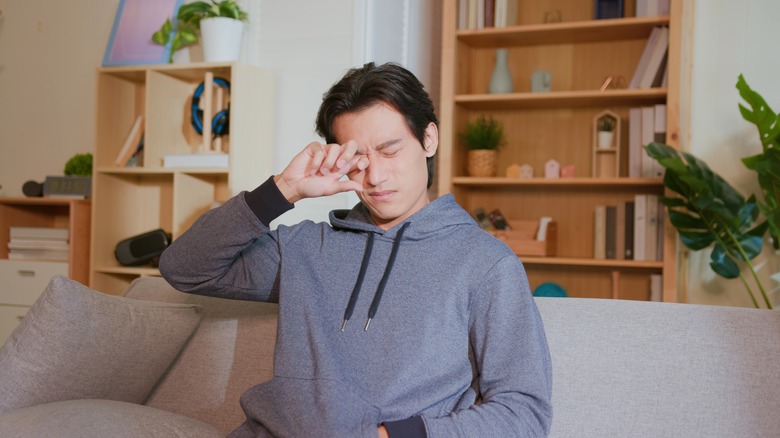 A man rubbing his eye
