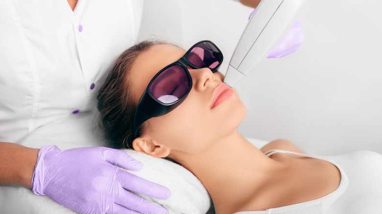Woman receiving laser hair removal on face