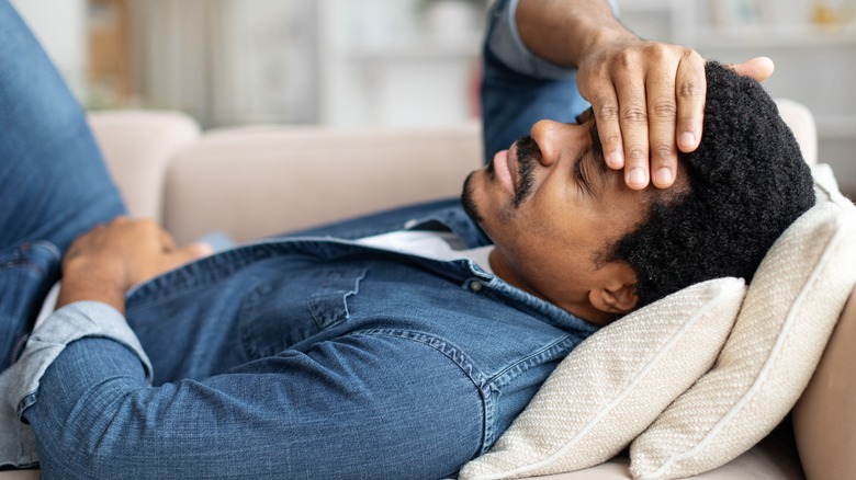 Sick man laying on couch