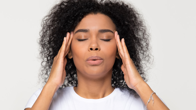Woman massaging temples and breathing