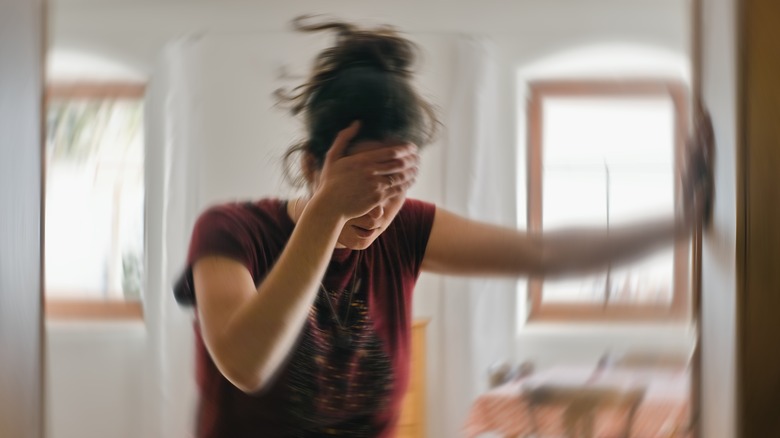 Dizzy woman leans against wall