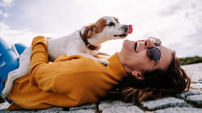 Woman laughing with her dog on her