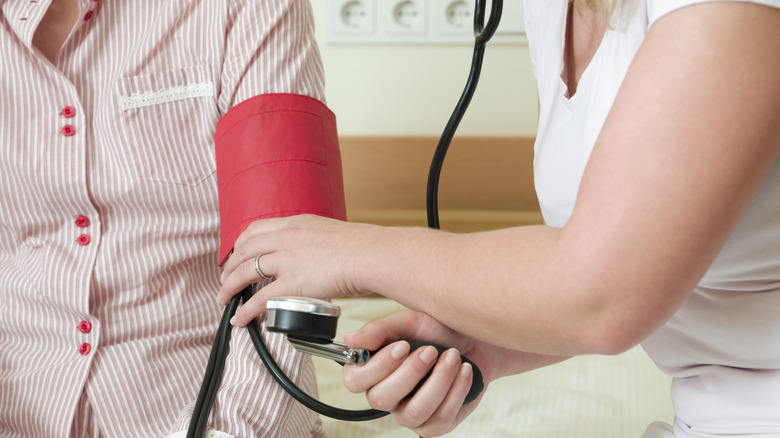 doctor taking patient's blood pressure