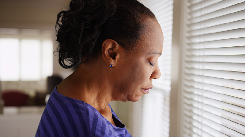 depressed-looking woman at window