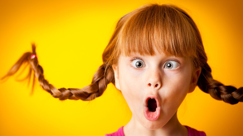 Young girl with pigtails crossing her eyes