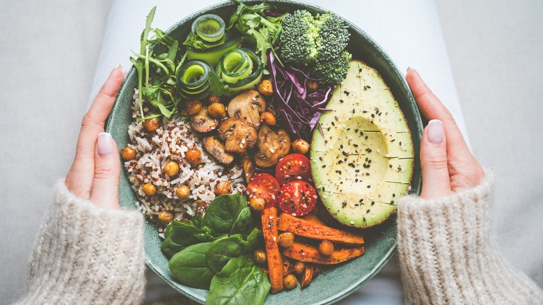 Person holding plate of vegetables