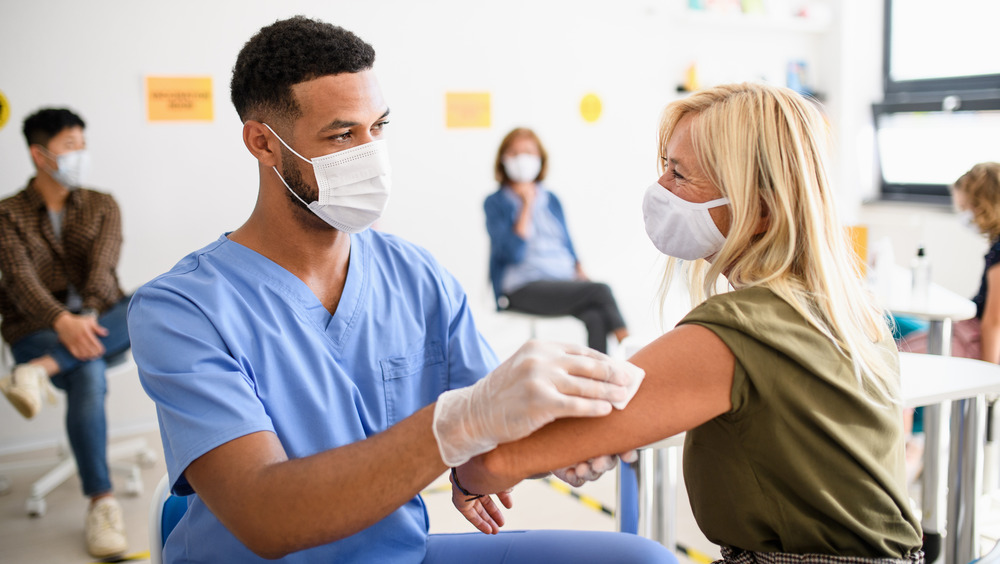 Nurse giving woman a COVID-19 vaccine