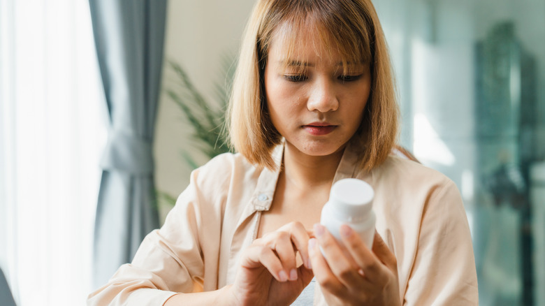 woman looking at a supplement label