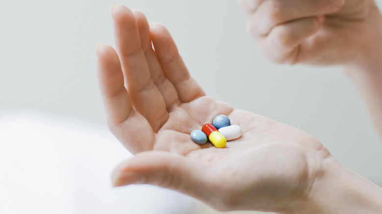 a woman's hand with several medications