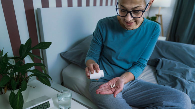 Woman taking medication at night