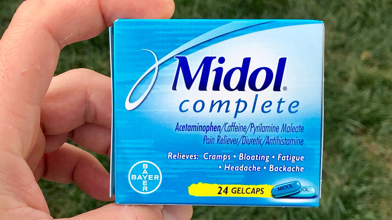 person holding box of Midol