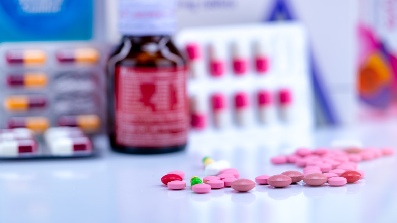 tablets of ibuprofen with other drugs in the background