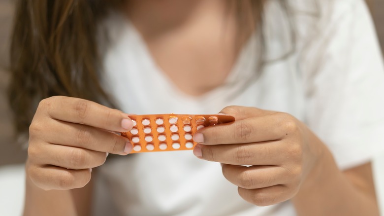 Hands holding birth control pack