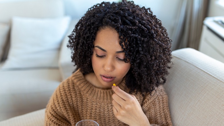 A woman with a cold taking pills