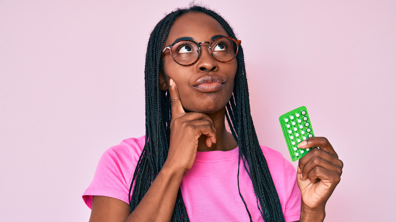 Pregnant woman holding birth control