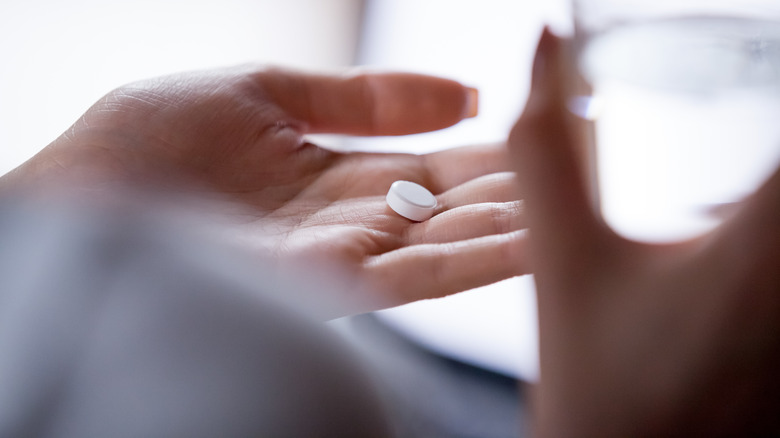 Woman holding birth control pill
