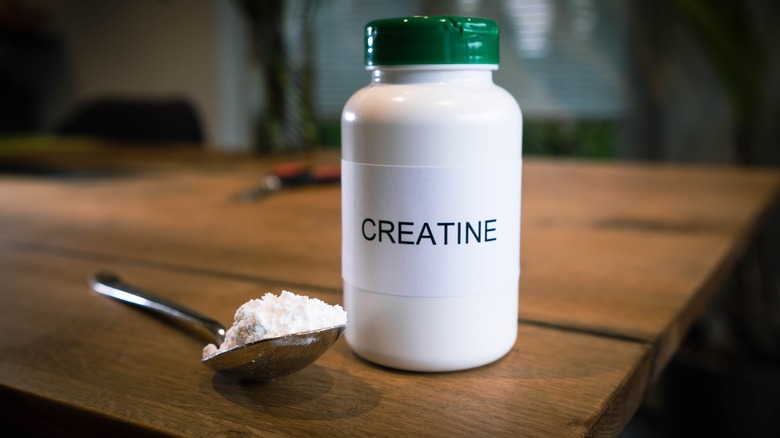 Bottle and spoonful of creatine