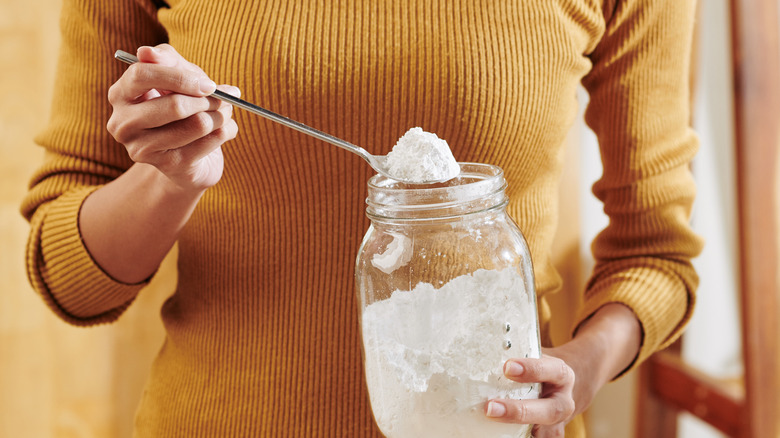 woman taking spoonful of baking soda