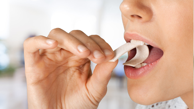 woman putting a piece of gum in mouth