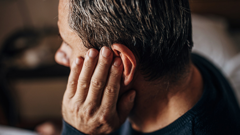 Man touching ear