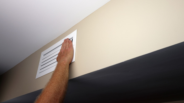 person's hand on an HVAC vent