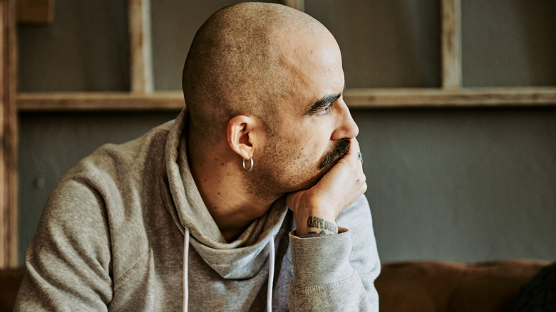 Man thinking leaning on palm