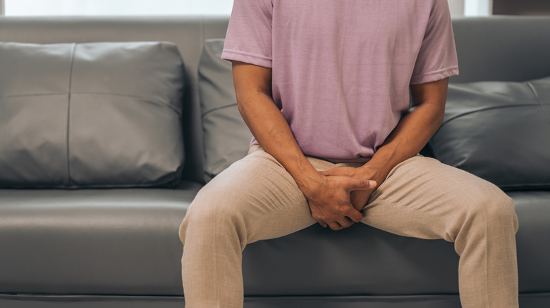 Man holding his groin area