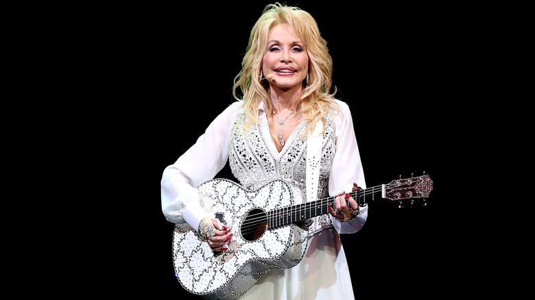 Dolly Parton performing in a white dress