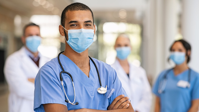 male healthcare worker smiling while wearing a mask