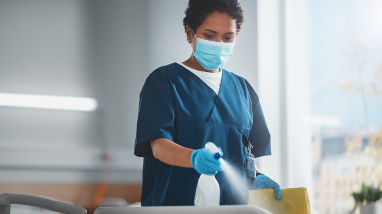 healthcare worker sanitizing hospital bed