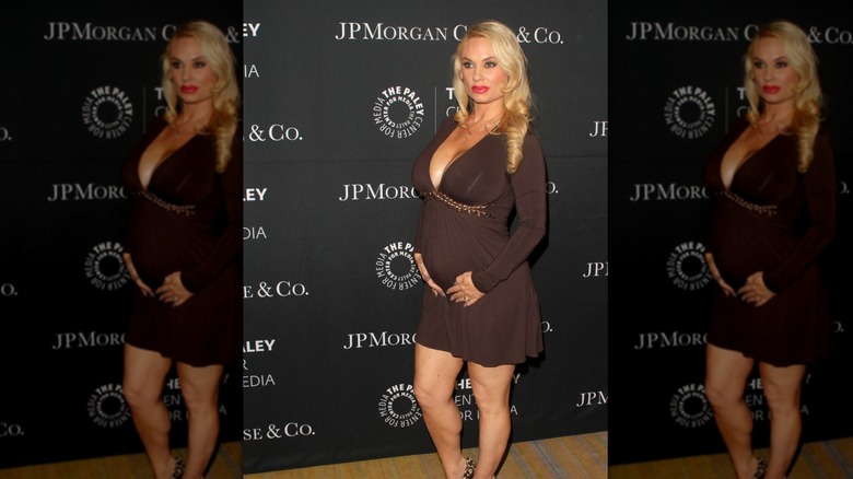 Coco Austin cradling her baby bump