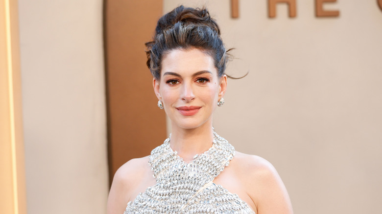Anne Hathaway posing in a white dress