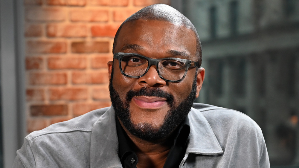 Tyler Perry with facial hair and wearing glasses 