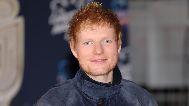 Close up on Ed Sheeran in a suede blue jacket.