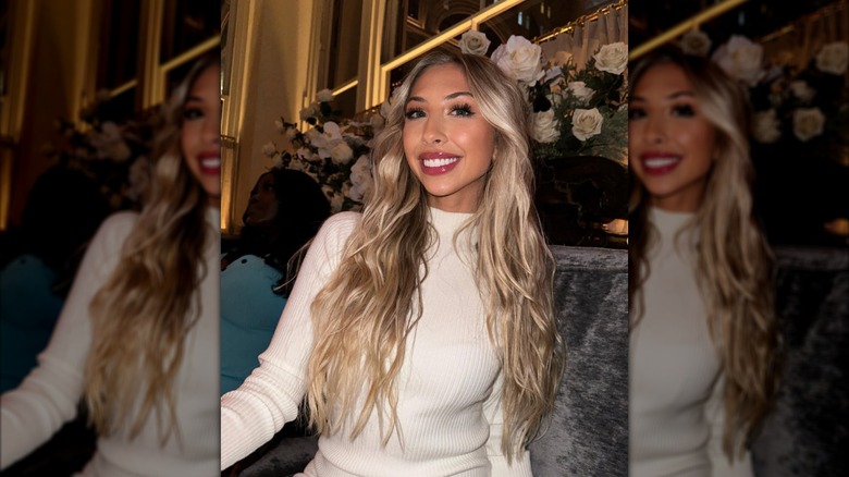 Taylor Brazinsky smiling in cream top with roses in background